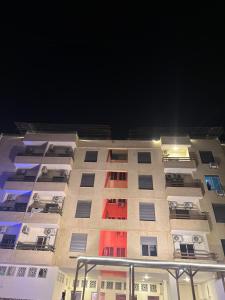 a tall building with colorful windows at night at Astana in Sowayma