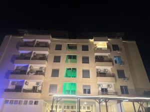 a tall building with colorful windows at night at Astana in Sowayma