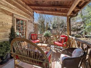 a porch of a cabin with chairs and a table at Melrose Cabin in Highlands