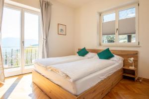 a bedroom with a large bed with two windows at Strengen Guesthouse in Caldaro