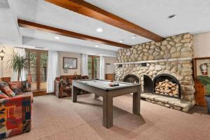 a living room with a pool table and a stone fireplace at Genteman Manor Private Indoor Pool Sauna & Lake in Sainte-Agathe-des-Monts
