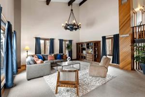 a living room with a couch and chairs and a chandelier at Genteman Manor Private Indoor Pool Sauna & Lake in Sainte-Agathe-des-Monts