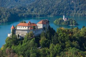 an island in the middle of a lake with a castle at Rooms Zima in Žirovnica