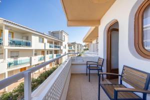 a balcony with two chairs and benches on a building at La Posada Boutique rooms Albir in Albir