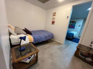 a bedroom with a bed and a table with a lamp at Caiquén Cabaña Punta Arenas in El Cerrillo