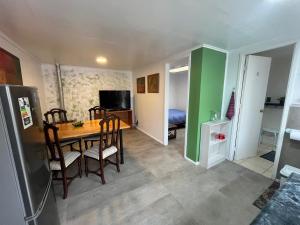 a kitchen with a table and chairs and a bedroom at Caiquén Cabaña Punta Arenas in El Cerrillo
