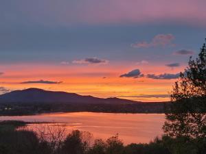 a sunset over a lake with mountains in the background at Apartament PLAY in Pietrzykowice