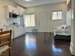 a kitchen and living room with a table and a couch at Spacious 2 Bedroom Suite in Burnaby Free Parking, Full Kitchen, Near Transit in Burnaby