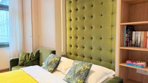 a bedroom with a large padded headboard next to a bed at Ruzop Apartament - Modern studio in center, self check-in, WiFi in Poznań