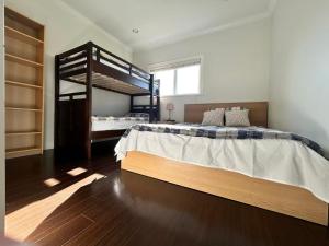 a bedroom with two bunk beds and a wooden floor at Spacious 2 Bedroom Suite in Burnaby Free Parking, Full Kitchen, Near Transit in Burnaby