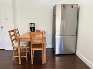 a kitchen with a table and a refrigerator at Spacious 2 Bedroom Suite in Burnaby Free Parking, Full Kitchen, Near Transit in Burnaby
