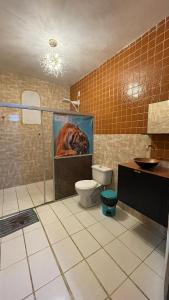a bathroom with a toilet and a painting of a horse at Pousada Apart Fraga Maia in Feira de Santana