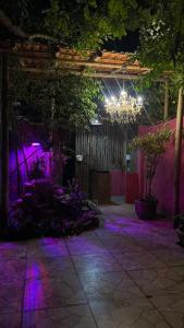 a room with a chandelier and purple lights at Pousada Apart Fraga Maia in Feira de Santana