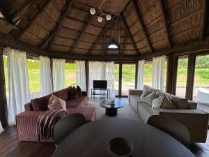 a living room with two couches and a table at Cabin by the pond in Wądołki Bućki