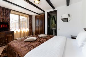 ein Schlafzimmer mit einem großen Bett und zwei Kissen darauf in der Unterkunft Casa Dudu in Moieciu de Jos