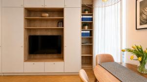 a living room with a television in a white cabinet at Ruzop Apartament - Modern studio in center, self check-in, WiFi in Poznań