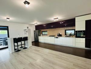 a large kitchen with white cabinets and a bar in it at Luxury 3 Bedroom Pool Villa in Gulia