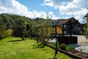 ein Hof mit einem Haus und einem Garten mit Bäumen in der Unterkunft Casa Dudu in Moieciu de Jos