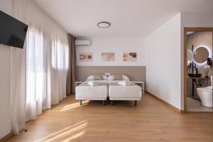 a white bedroom with a bed and a bathroom at La Posada Boutique rooms Albir in Albir