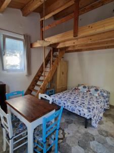 a room with a bed and a table and a bunk bed at A Bugatta in Ìsola di San Pietro
