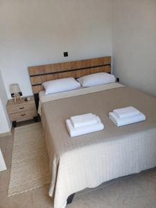 a bedroom with a large bed with two towels on it at DANAI'S Sea Whisper in Lékhaion