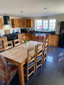 a kitchen with a wooden table with a vase of flowers on it at Southview Farm, Hambleton, Poulton-Le-Fylde in Hambleton