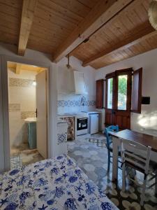 a kitchen with a table and a dining room at A Bugatta in Ìsola di San Pietro