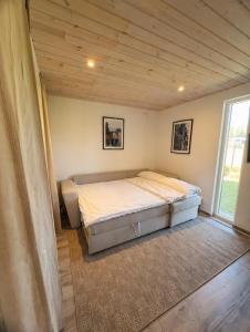 a bed in a room with a wooden ceiling at Villa Söderläget in Laholm