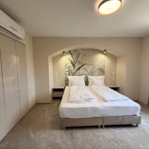 a bedroom with a large bed with a large headboard at Heritage Hall and More in Nagykálló