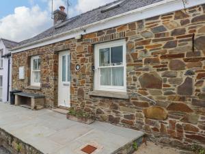a stone house with a white door and windows at Brynawelon in Newport