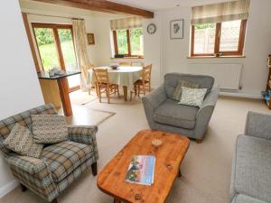 a living room with a table and a couch and chairs at Brynawelon in Newport