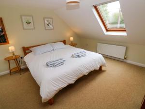a bedroom with a large white bed with a window at Brynawelon in Newport