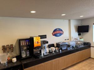 a restaurant with a counter with a coffee machine at River House Inn, a Baymont by Wyndham in Florence