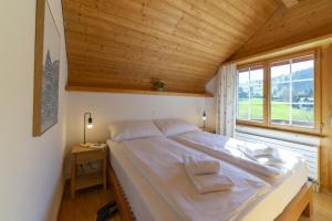 a large bed in a room with a window at Dachnest in Unterwasser