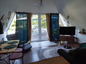 a living room with a couch and a tv and a table at Farm Ház in Fonyód