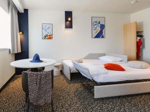 a hotel room with two beds and a table at Hotel ibis Rennes Centre Gare Sud in Rennes +117 photos