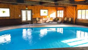 a large pool in a room with chairs and tables at Adirondack Lodge Old Forge in Old Forge