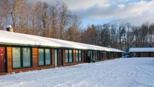 a wooden building with snow on top of it at Adirondack Lodge Old Forge in Old Forge