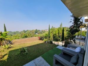 a patio with two couches sitting on a lawn at Villa Mahlin 3 kamar in Tutugan