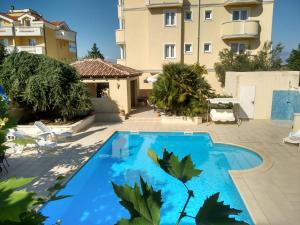 a swimming pool in front of a building at Aparthotel Lekavski in Zaton