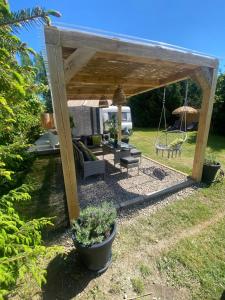 a wooden pergola with a bench and a swing at Camping Abordaż Wolin in Kołczewo