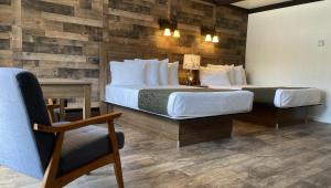 a hotel room with two beds and a chair at Adirondack Lodge Old Forge in Old Forge +53 photos