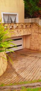 a building with a garage and a stone wall at Duplex in Pinamar