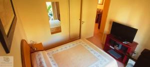 a bedroom with a mirror and a bed and a television at Duplex in Pinamar +1 photo