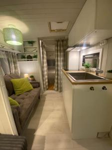 a kitchen and living room with a couch and a sink at Camping Abordaż Wolin in Kołczewo