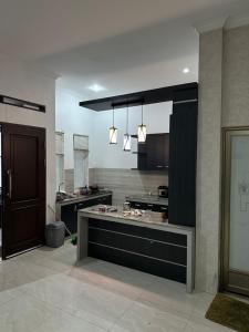 a large kitchen with a counter in the middle at Villa Mahlin 3 kamar in Tutugan