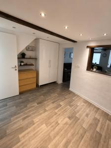 an empty living room with wooden floors and a kitchen at Gemütliche Ferienwohnung in Hackenheim +10 photos