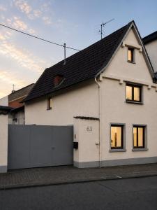 a white house with a black roof at Gemütliche Ferienwohnung in Hackenheim