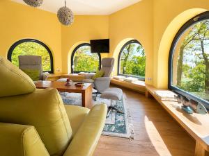a living room with yellow walls and arched windows at Wasserturm Putbus in Putbus