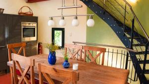 a dining room with a wooden table and a staircase at Wasserturm Putbus in Putbus
